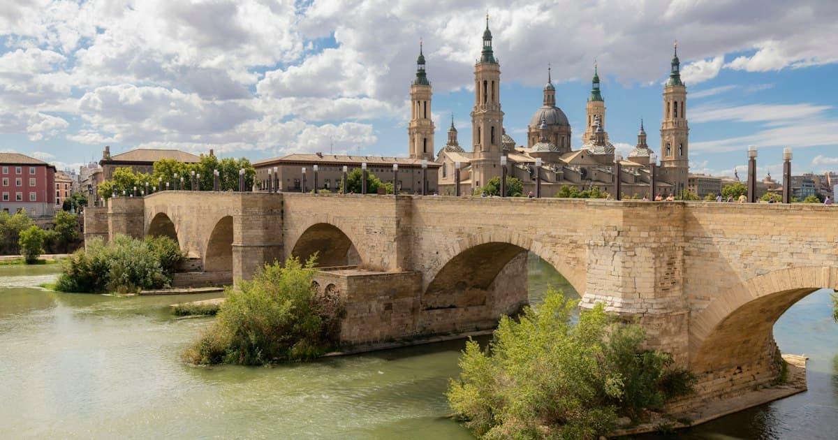 El Puente de Piedra sobre el río Ebro a su paso por Zaragoza, con las torres y la cúpula de la Basílica del Pilar al fondo