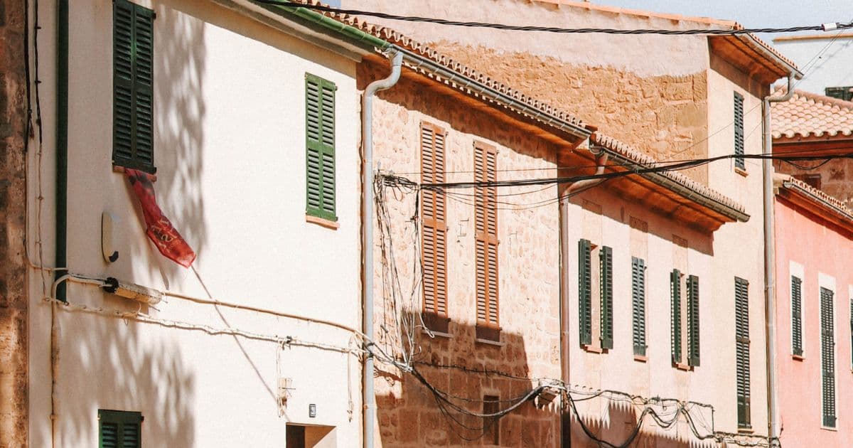 Fachadas de casas de un pueblo de Mallorca con persianas verdes